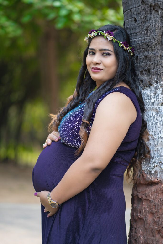 Maternity Photography 1 A pregnant women standing next to a tree
